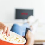 crop-woman-eating-popcorn-and-watching-series-in-living-room-1024×712-min